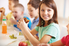 young Girl smiling eating lunch