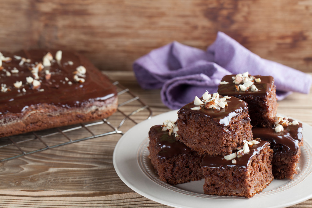 stack of chocolate Brownies on  white plate on a wooden table