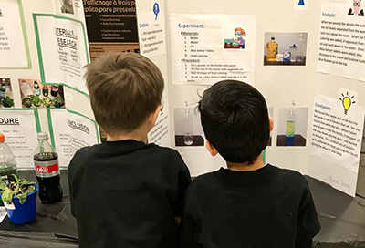 Children reading science fair projects at Enders Salk