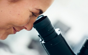 Scientist looking through microscope