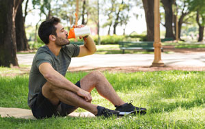 Outdoor exerciser drinking from sports bottle