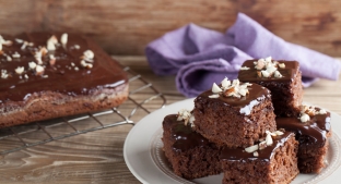 stack of chocolate Brownies on  white plate on a wooden table