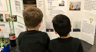 Children reading science fair projects at Enders Salk