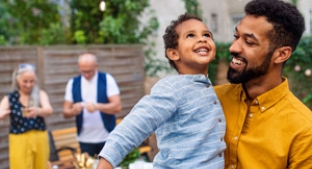 Smiling son and father with grandparents in the background