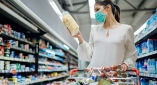 Female shopper with trolley wearing a mask