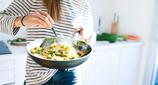 Woman cooking a healthy meal in a wok